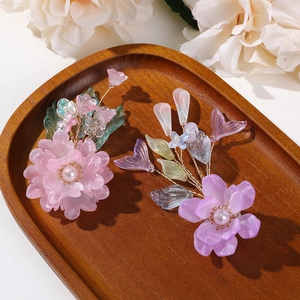 Détail d'épingles à cheveux fleurs faites main avec pétales en résine et fil doré