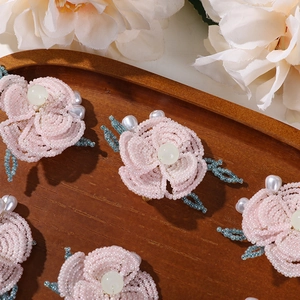 Detalle de flor de cuentas rosa con toques de perlas en bandeja de madera para bricolaje