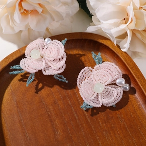 Vista detallada de flores de cuentas rosas hechas a mano con perlas de gota