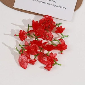 Macro detail of red acrylic flower petals and green beads for DIY jewelry making