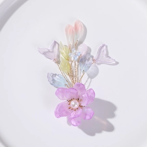 Détail macro d'un accessoire de cheveux en résine de fleur violette et perles