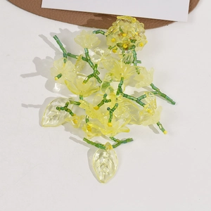 Detail of handmade beaded flower in yellow and green resin for DIY jewelry making