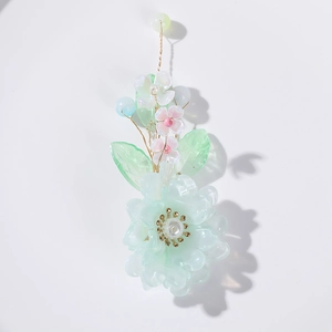 Détail d'un accessoire floral fait main avec pétales verts et fil de fer doré