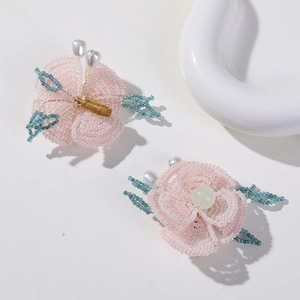 Detalle de flor de cuentas rosa hecha a mano con doble capa y centro de perla blanca