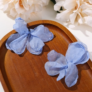Detail von hellblauen Netz-Schmetterling-Haarspangen auf Holztablett mit weißen Blumen