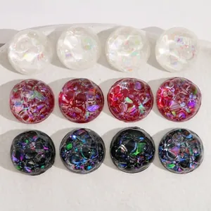 Close-up of DIY glitter resin round charms in white, red and black for crafts