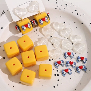 Detail of DIY butterfly bow jewelry components and resin charms on display tray