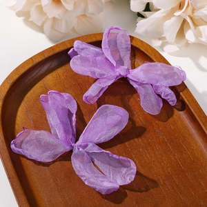 Detailansicht zweier handgefertigter lila Organza-Blüten für DIY-Haarschmuck