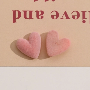 Dettaglio ravvicinato di ciondoli a cuore floccati rosa che mostrano la texture morbida