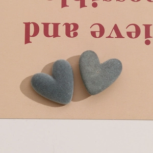 Dettaglio macro di due ciondoli a cuore floccato in blu polvere per creazioni di gioielli DIY