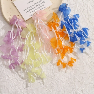 Macro shot of colorful acrylic flower petal tassel earrings with delicate glass beads