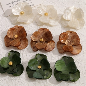 Detailed close-up of acrylic flower charms with pearl, amber, and marble textures