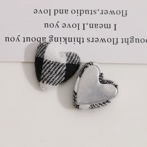 Close-up of heart-shaped fabric buttons with black and white plaid pattern for DIY crafts
