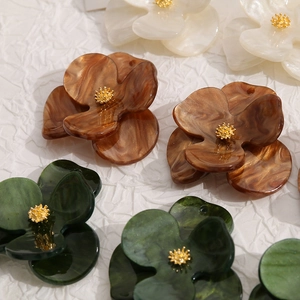 Detailed close-up of acrylic flower charms with marble texture and golden stamens