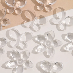 Close-up of faceted acrylic butterfly and flower charms for DIY jewelry making