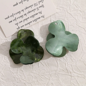 Macro detail of acrylic tri-petal flower charms with marble texture and glitter finish