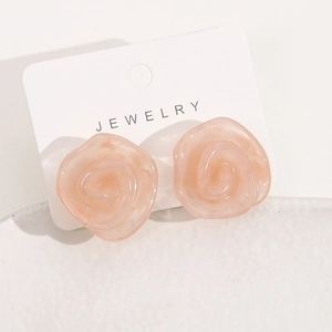 Boucles d'oreilles rose en résine sur une carte à bijoux blanche au fini mat