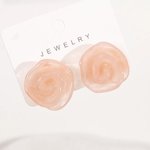 Vue détaillée des boucles d'oreilles fleurs en résine pêche avec texture marbrée sur carte