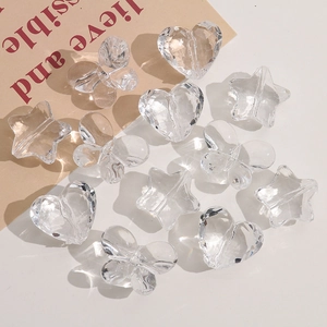 Detailed view of clear faceted acrylic heart star and butterfly beads for DIY jewelry