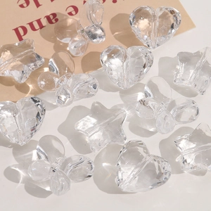 Macro view of clear faceted acrylic beads in heart, star, and butterfly shapes for DIY jewelry