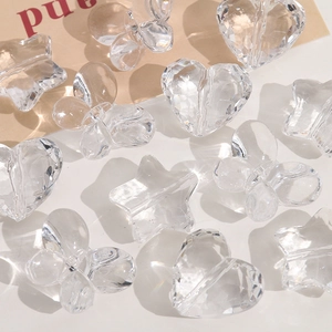 Macro detail of transparent multi-faceted acrylic beads in heart, star, and butterfly shapes