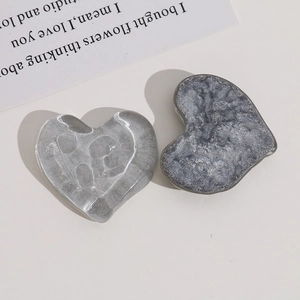 Macro detail of irregular heart-shaped resin charms with water ripple and marble textures
