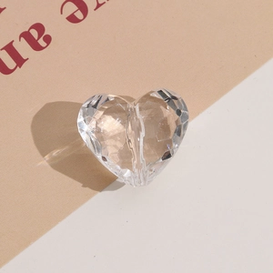 Macro shot of transparent faceted heart crystal bead with vertical hole for DIY jewelry