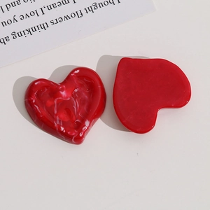 Detail showing red marble-patterned resin heart charms on a minimalist background