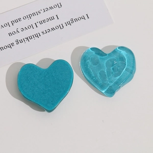 Macro detail of wave-textured translucent heart resin charms in cyan and blue
