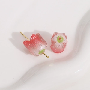 Macro shot of glittery pink gradient tulip resin beads with gold metal T-pin attachment
