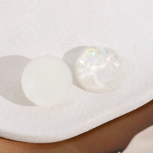 Detail of 20mm round resin cabochons with white matte and iridescent AB gradient finish