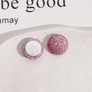 Vue macro de boutons en métal pailleté rose de 15mm avec un dos magnétique argenté