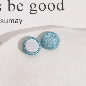 Gros plan sur des boutons magnétiques ronds à paillettes bleues 15 mm pour bijoux DIY