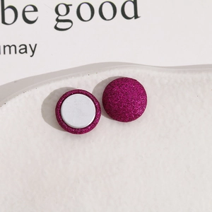 Vue macro de boucles d'oreilles magnétiques pailletées rose pourpre à texture givrée