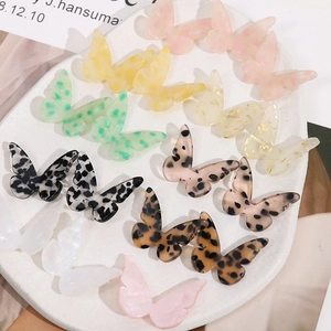 Detailweergave van diverse acetaat vlinderbedeltjes met luipaardprint voor sieraden