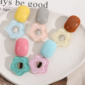 Colorful resin flower hair clips in a white ceramic dish with pastel macaron shades