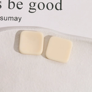 Detail van 20mm beige vierkante harsstukken voor DIY-sieraden in een keramische schaal