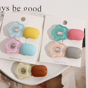 Close-up of colorful resin flower and oval hair clips set on a display card