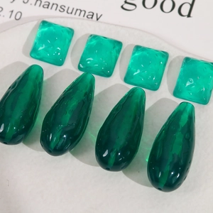 Detail of emerald green translucent resin beads with hammer texture for DIY jewelry