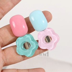 Handheld view of resin floral and oval hair clips with sparkling glitter finish details