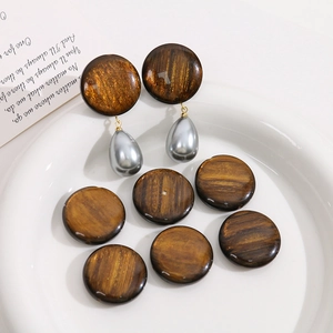 Gros plan de perles en résine marron pailletée et pendentifs perles gouttes argentées