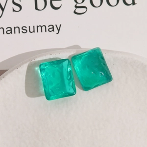 Macro detail of square translucent green resin earrings with ripple textured surface