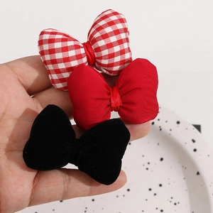 Three-piece hair bow set in red plaid, satin, and black velvet on a minimalist background