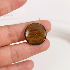 Vue macro d'une perle ronde en résine marron foncé de 24mm avec paillettes dorées DIY