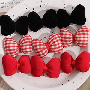 Macro shot of 9-piece bow hair accessories in black velvet, plaid and red cotton fabrics