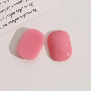 Close-up of pink oval resin cabochons for DIY jewelry making on a minimalist background
