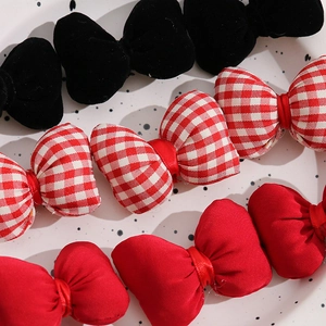 Close-up of velvet and checkered bow hair accessories on a polka dot ceramic plate
