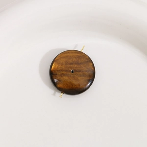 Détail macro d'une perle ronde en résine marron foncé de 24mm avec texture de sable doré