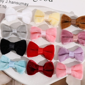Detailed view of twelve colorful handmade velvet bows neatly arranged in a white ceramic dish