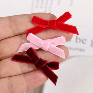 Detailed view of handmade velvet ribbon bows in red, pink, and burgundy for DIY accessories